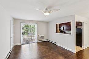 Colonia apartment for rent - A room with a ceiling fan and a window with a view of a fence and trees.