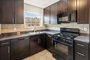 Woodbridge apartment for rent - a kitchen with stainless steel appliances and black cabinets