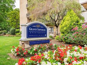 Hackensack apartment for rent - our sign in front of our building with flowers on the ground