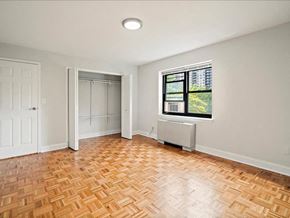 Hackensack apartment for rent - an empty living room with wood flooring and a window