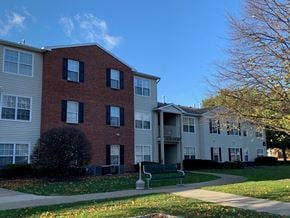 Wayne apartment for rent - a park bench in front of a brick apartment building