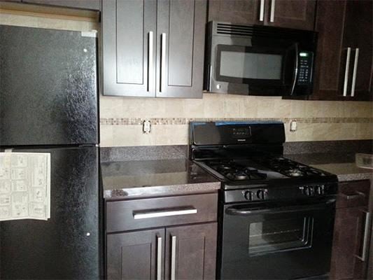 Wayne apartment for rent - A black refrigerator with a magnet on it sits next to a black stove in a kitchen.