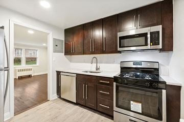 Belleville apartment for rent - a kitchen with wooden cabinets and a stove and a microwave