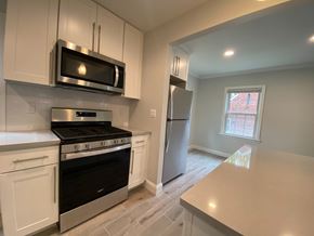 Tenafly apartment for rent - a kitchen with white cabinets and stainless steel appliances