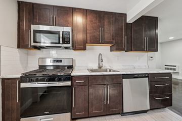 West Orange apartment for rent - A kitchen with dark brown cabinets and stainless steel appliances.