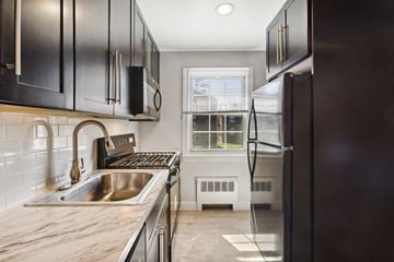 Orange apartment for rent - a kitchen with a sink and refrigerator and a window