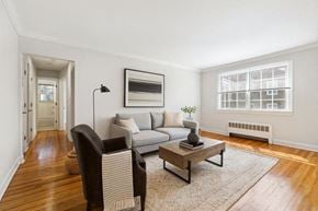 Orange apartment for rent - A living room with a grey couch, a brown chair, and a coffee table.