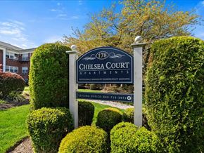 Caldwell apartment for rent - A sign for Chelsea Court Apartments stands in front of a building.