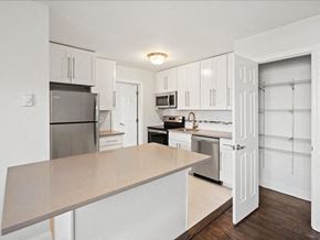 Caldwell apartment for rent - A kitchen with white cabinets and a wooden island.