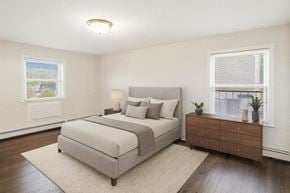 Caldwell apartment for rent - A bedroom with a large bed, a nightstand, and a window with blinds.