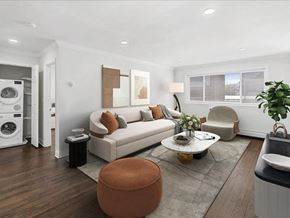Caldwell apartment for rent - A modern living room with a white sofa, a brown ottoman, and a grey rug.