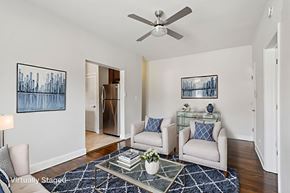 Cranford apartment for rent - A living room with a white couch, a glass coffee table, and a ceiling fan.