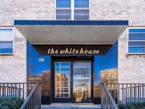 Bloomfield apartment for rent - The front of a building with a sign that says "The White House" and a black door.