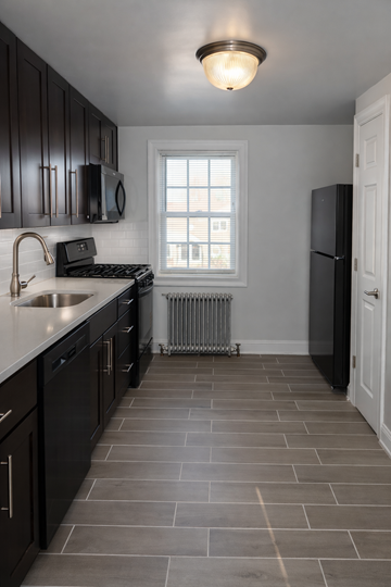 Long Branch apartment for rent - A kitchen with black cabinets and a white door.