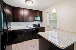 Newton apartment for rent - a kitchen with black appliances and a marble counter top