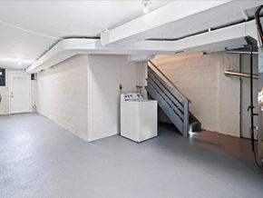 Summit apartment for rent - the basement of a building with a staircase and a refrigerator