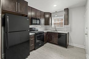 Highland Park apartment for rent - a kitchen with black appliances and dark wood cabinets