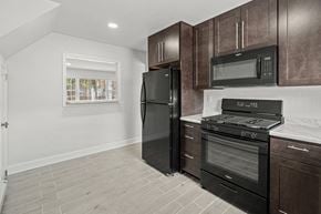 Highland Park apartment for rent - a kitchen with black appliances and dark wood cabinets
