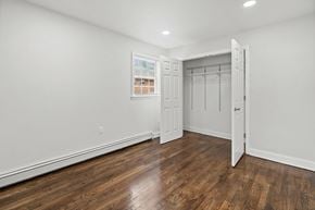 Highland Park apartment for rent - a bedroom with white walls and wood flooring and a closet