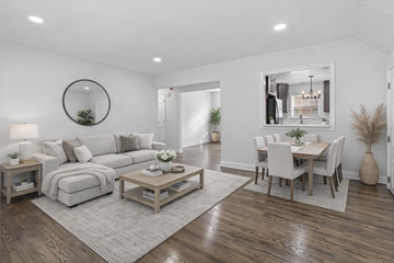 Highland Park apartment for rent - A modern living room with a grey sofa, a white dining table and chairs, and a wooden coffee table.