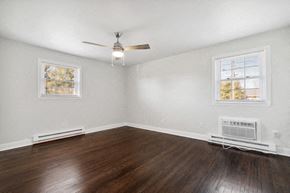 Washington apartment for rent - an empty living room with wood floors and a ceiling fan