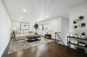 Washington apartment for rent - A modern living room with a white couch, a coffee table, and a rug.