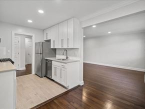 Montclair apartment for rent - an empty kitchen with white cabinets and a stainless steel refrigerator