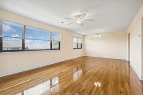 Iselin apartment for rent - an empty living room with a large window and a ceiling fan