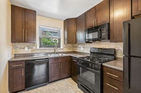 Iselin apartment for rent - a kitchen with black appliances and wooden cabinets