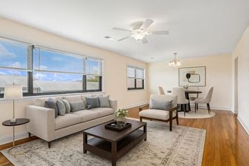 Iselin apartment for rent - A living room with a grey couch, a coffee table, and a dining table with chairs.