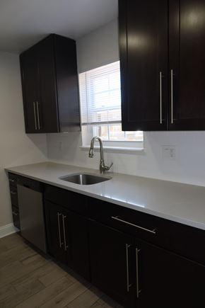 Aberdeen apartment for rent - A kitchen with black cabinets and a white countertop.