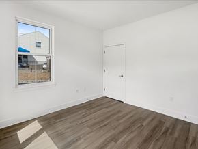 Madison apartment for rent - A room with a white door and a window showing a blue building outside.