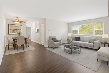 Woodbury apartment for rent - A living room with a white couch, a coffee table, and a dining table with chairs.