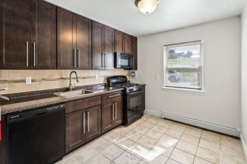Dover apartment for rent - a kitchen with wooden cabinets and a sink and a window