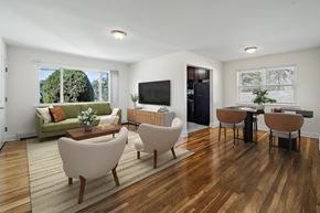 Dover apartment for rent - A living room with a green couch, a coffee table, and a television.