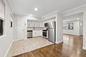 Metuchen apartment for rent - an empty living room with a kitchen with stainless steel appliances