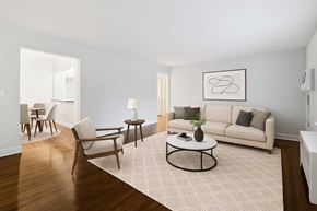 Red Bank apartment for rent - A living room with a white couch, a coffee table, and a rug.