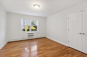 South River apartment for rent - an empty bedroom with white walls and wood floors and a window