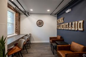 Summit apartment for rent - a lounge area with couches and chairs and a clock on the wall