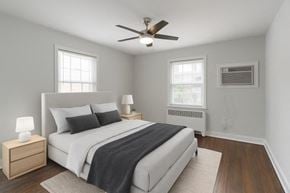 Moorestown apartment for rent - A bedroom with a bed, nightstands, and a ceiling fan.