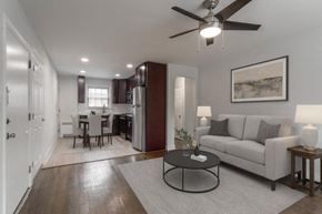Moorestown apartment for rent - A living room with a grey couch, a black coffee table, and a ceiling fan.