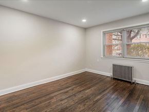 Hasbrouck Heights apartment for rent - A room with wooden floors and a window with a view of a building outside.