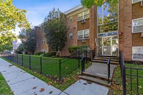Orange apartment for rent - an apartment building with a sidewalk and a fence in front of it