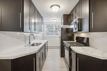 Orange apartment for rent - a kitchen with stainless steel appliances and marble counter tops