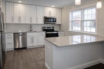 Springfield apartment for rent - A kitchen with white cabinets and a stainless steel refrigerator.