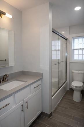 Springfield apartment for rent - A white bathroom with a toilet, sink, and mirror.