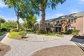 Caldwell apartment for rent - the front yard of a brick house with a cobblestone walkway and trees