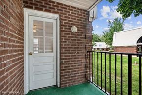 Frenchtown apartment for rent - the entrance to a brick house with a white door and a balcony