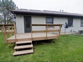 Dewitt triplex for rent - a house with a deck and stairs in a yard