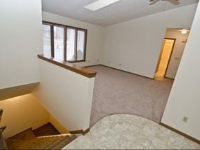 Dewitt triplex for rent - an empty living room with a staircase and a window